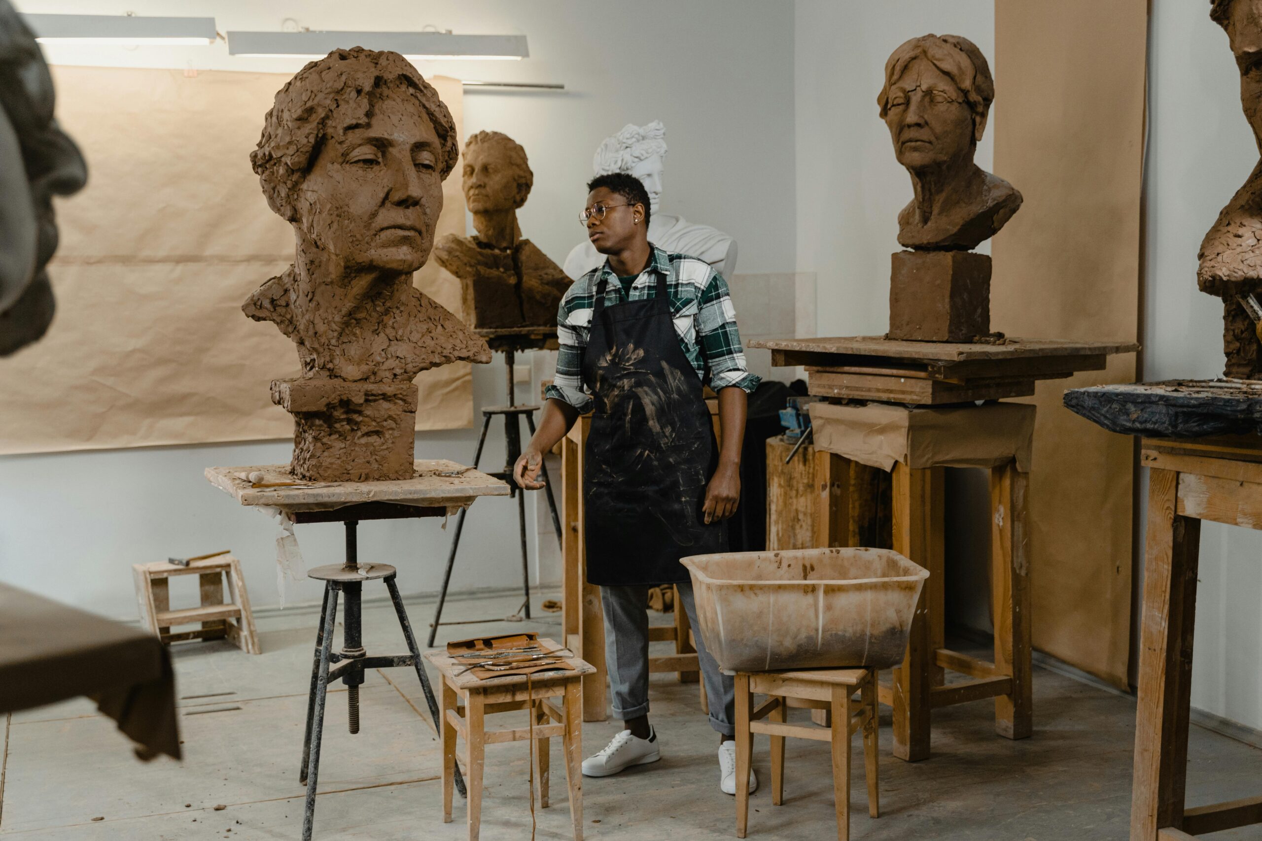 Talented artist working on detailed clay sculptures in an art studio setting.